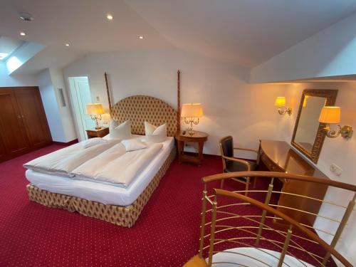 una habitación de hotel con una cama grande y una escalera en Alpenhof en Bayrischzell
