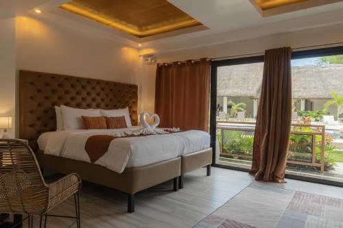 a bedroom with a large bed and a large window at The Mayana Resort in Dauis