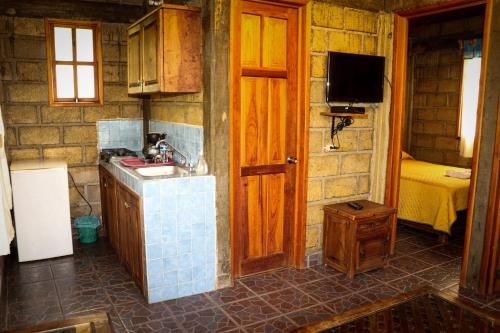 a small kitchen with a sink and a tv at Casa Rural Santa Maria Regla in Huasca de Ocampo