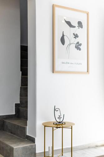 a table with a picture on the wall next to a staircase at Casa Aelia ,Stelida Naxos in Stelida