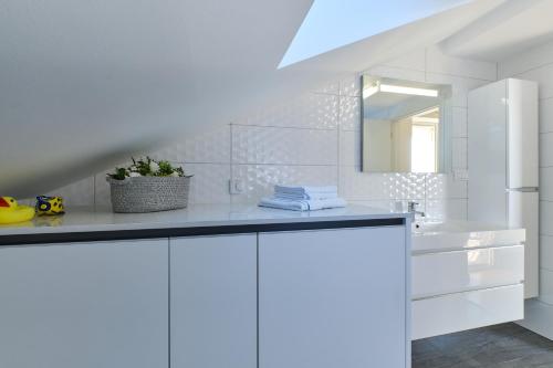 Baño blanco con lavabo y espejo en Brunohome - design apartment by the sea en Mali Lošinj