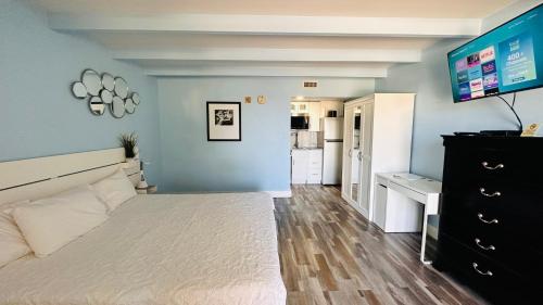 a bedroom with a large white bed and a television at TAMPA BAY, BEACH step away, WIFI, FREE PARKING,POOLS, JACUZZI in Ruskin