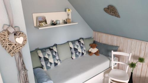 a small room with a couch with a teddy bear at Landhaus Anneliese in Oberkotzau
