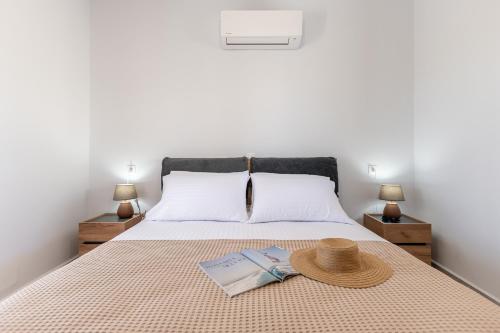 a bed with a hat and two books on it at Casa Aelia ,Stelida Naxos in Stelida