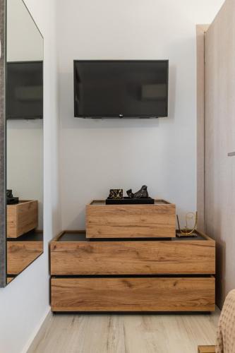 a living room with a tv on a white wall at Casa Aelia ,Stelida Naxos in Stelida