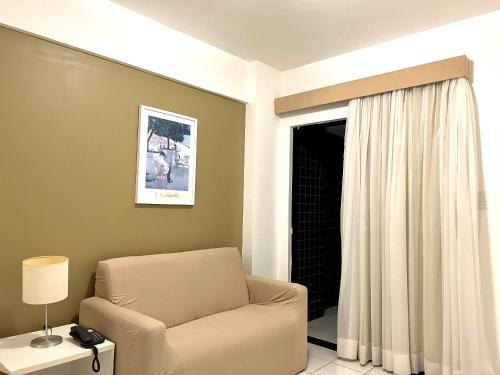 a living room with a chair and a window at Biarritz temporadalitoranea in São Luís