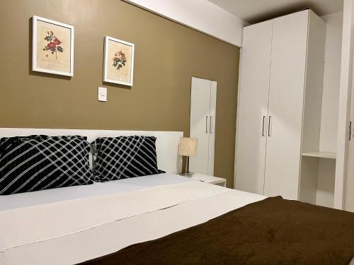 a bedroom with a large bed and white cabinets at Biarritz temporadalitoranea in São Luís