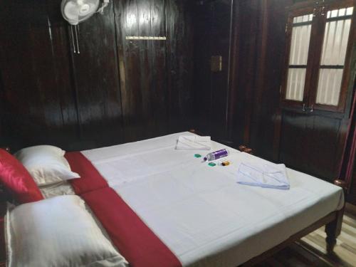 a white bed with pills and papers on top of it at Homely Home stay in Kalpetta