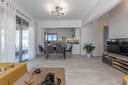 a living room with a dining table and a kitchen at Casa Aelia ,Stelida Naxos in Stelida