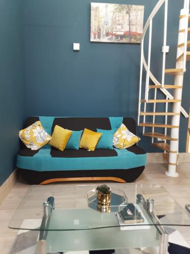 a living room with a blue couch and a glass table at Grange cottage in Edenderry