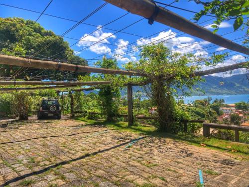 a view from the porch of a house with a car parked at Casas D'Água Doce - Casa Bambuzinho in Ilhabela