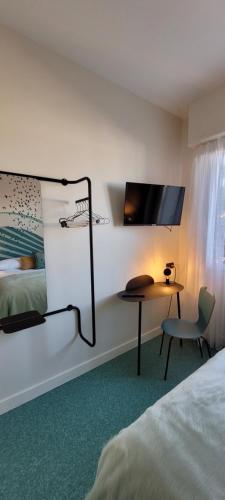a hotel room with a bed and a desk and a tv at Seakub hotel in Royan