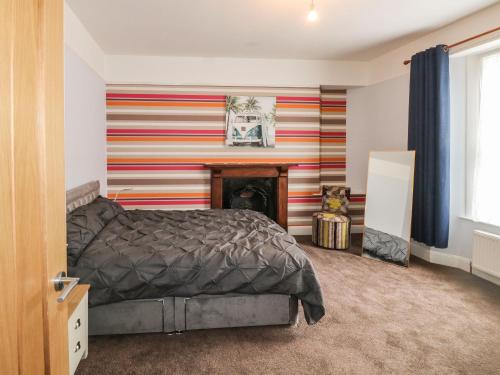a bedroom with a bed and a striped wall at 11 Magdalene Road in Torquay
