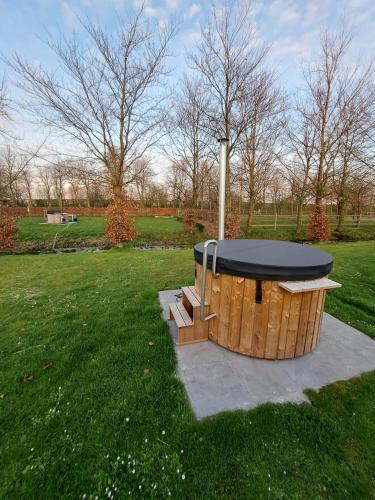 a hot tub with a black top in a park at Domein Den Buiten Bed And Breakfast DnD in Sint-Niklaas