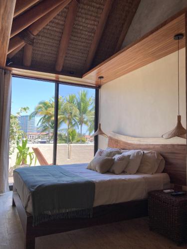 a bedroom with a large bed with a large window at Villa KaiKai Marina Ixtapa in Ixtapa