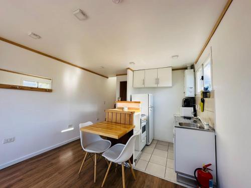 - une petite cuisine avec une table en bois et des appareils électroménagers blancs dans l'établissement Gi 's House, à Ushuaia