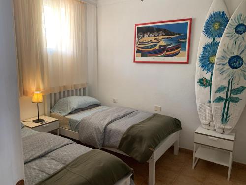 1 dormitorio con 2 camas y una foto en la pared en La Mar 2 bed 2 bath in sought after position FREE WIFI, en Puerto de Santiago