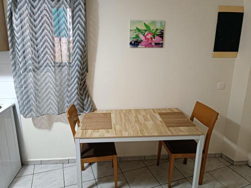 a table and chairs in a kitchen with a curtain at Two-storey maisonette next to the port in Mantoúkion