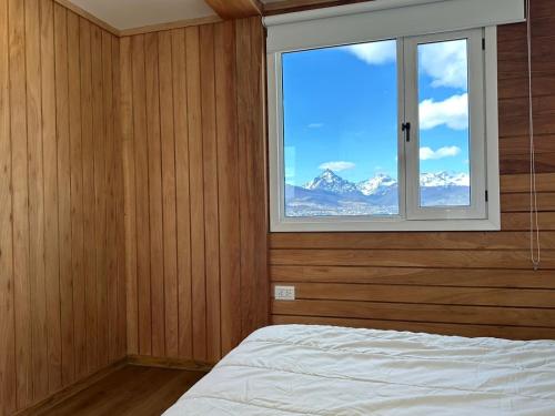 - une chambre avec une fenêtre offrant une vue sur la montagne dans l'établissement Gi 's House, à Ushuaia