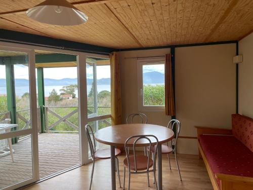 a dining room with a table and chairs and a balcony at Lavallee in Campomoro