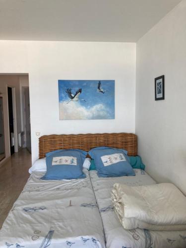 ヴィルヌーヴ・ルベにあるGrand studio vue mer à Marina Baie des Angesの空を飛ぶ鳥2羽のベッド1台