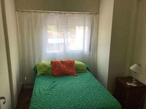 Dormitorio pequeño con cama y ventana en Edificio Fenizi en Monte Hermoso