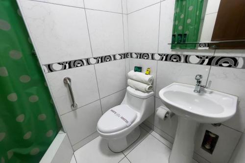 uma casa de banho com um WC branco e um lavatório. em Hotel Perú Pacífico em Lima