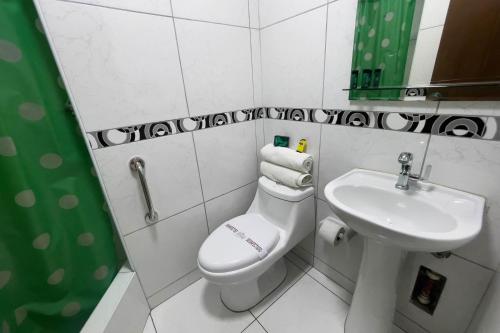 a bathroom with a white toilet and a sink at Hotel Perú Pacífico in Lima