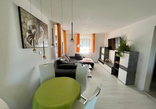 a living room with a green table and a couch at Ferien- und Businesswohnung Relax im ersten Stock in Sonnen