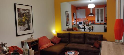 ein Wohnzimmer mit einem braunen Sofa und einer Küche in der Unterkunft Studio Quartier haut in Sète