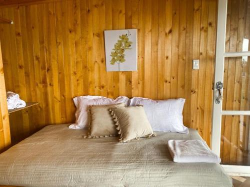 a bed in a room with a wooden wall at La Carreta in Aquitania