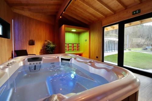 uma grande banheira num quarto com uma grande janela em Hotel Val de l'Our em Burg-Reuland
