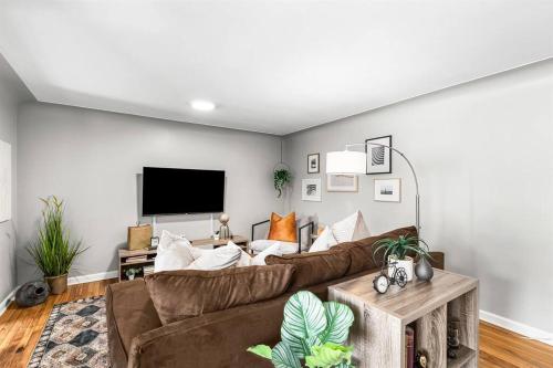 a living room with a couch and a flat screen tv at Warm & Comfy 2BR, Huge Backyard, Great Location! in Shelby