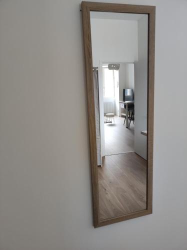a mirror on a wall next to a living room at Résidence Manivi in Beaupréau
