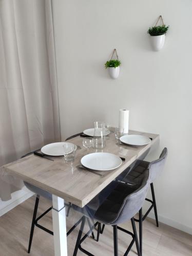 a wooden table with chairs and wine glasses on it at Résidence Manivi in Beaupréau