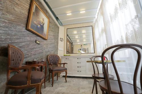 Salón con sillas, mesa y espejo en Di Valentina Boutique Living en Sliema
