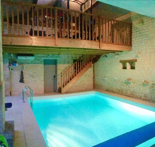 - une grande piscine dans un bâtiment avec un escalier dans l'établissement Gîte La Campeloise, à Villiers-en-Plaine