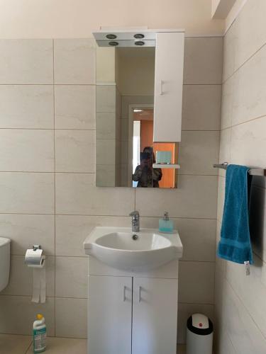 a bathroom with a white sink and a mirror at Belleview Heights in Limassol