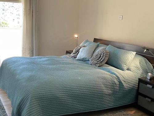 a bed with a blue comforter in a bedroom at Belleview Heights in Limassol