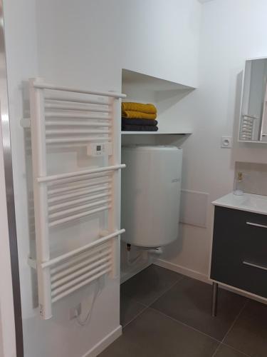uma pequena cozinha com prateleiras brancas e um lavatório em Appartement entre Saint-Malo, Dinard, Dinan et Dol em Miniac-Morvan