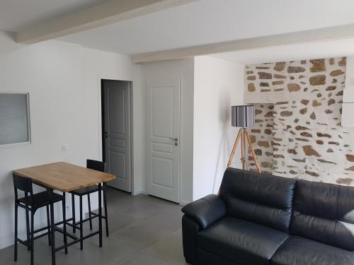 ein Wohnzimmer mit einem Sofa und einem Tisch in der Unterkunft Appartement entre Saint-Malo, Dinard, Dinan et Dol in Miniac-Morvan