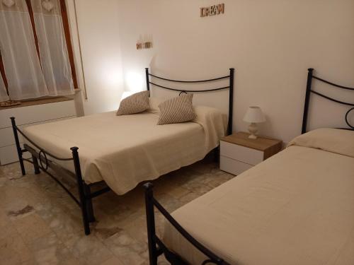 ein Schlafzimmer mit 2 Betten und einer Lampe auf einem Tisch in der Unterkunft Bilocale con ingresso indipendente Katia in Massa