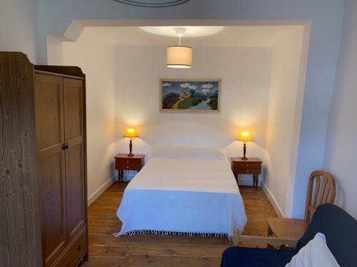 1 dormitorio con 1 cama blanca y 2 mesitas de noche en La Toscana en Lozoya en Alameda del Valle