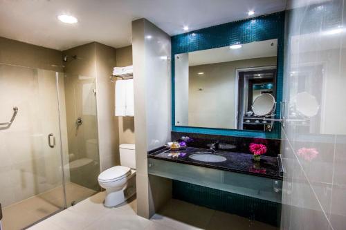 a bathroom with a sink and a toilet and a mirror at Lidotel Paraguaná in Punto Fijo