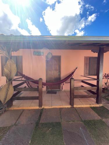 a house with a hammock in front of it at Pousada Licuri in Serra do Cipo