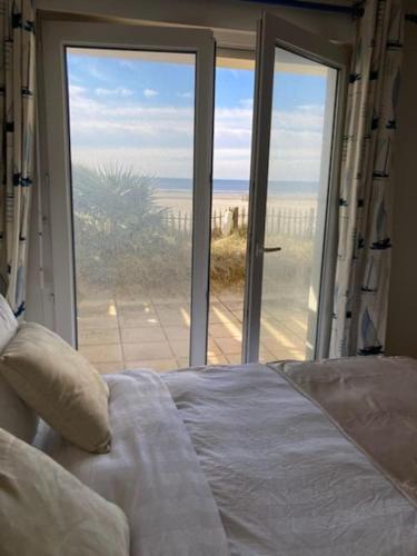 une chambre avec un lit et une vue sur la plage dans l'établissement Appartement La plage, à Berck-sur-Mer