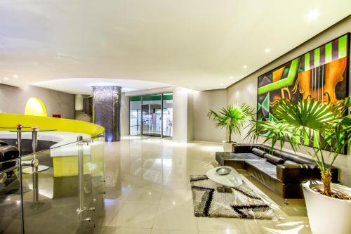 a lobby with a couch and some plants at Lidotel Paraguaná in Punto Fijo