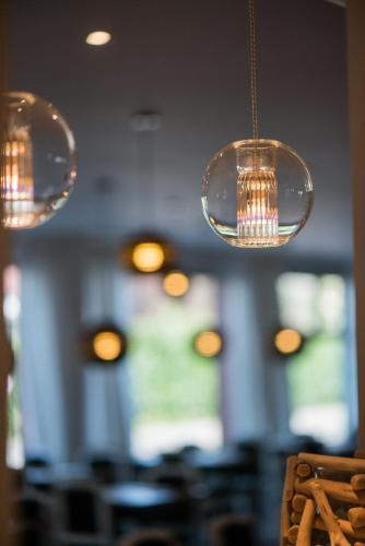 three lights hanging from the ceiling in a restaurant at Hôtel Catalpa in Annecy