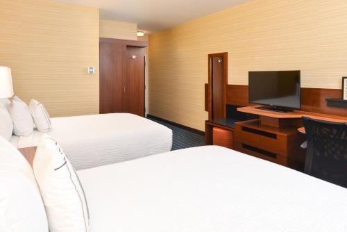 a hotel room with two beds and a desk with a television at Fairfield Inn & Suites by Marriott Gallup in Gallup