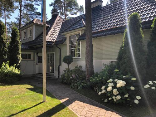 a house with a garden and a house at Villa Muusa with a cozy sauna, swimming pool and large beautiful garden in Tallinn